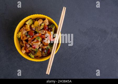 poulet yakissoba dans un bol jaune. Banque D'Images