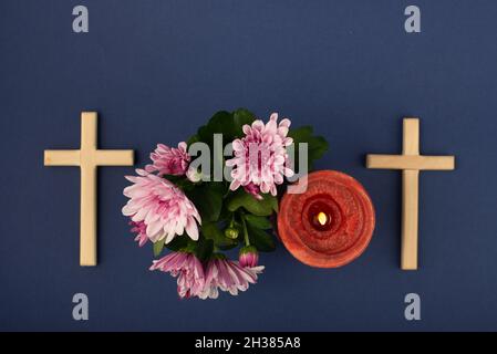 Composition de bougie brûlante, fleurs et croix en bois pour toutes les âmes jour.Convient également aux funérailles, au deuil, au deuil. Banque D'Images