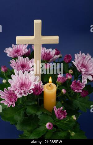 Composition de bougie brûlante, fleurs et croix en bois pour toutes les âmes jour.Convient également aux funérailles, au deuil, au deuil. Banque D'Images