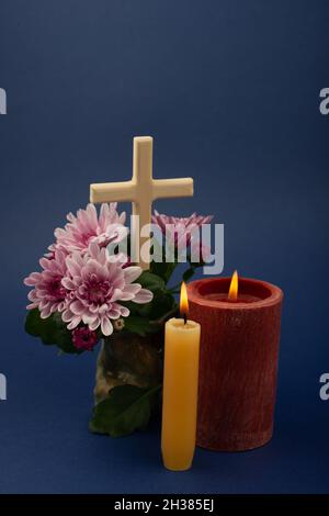 Composition de bougie brûlante, fleurs et croix en bois pour toutes les âmes jour.Convient également aux funérailles, au deuil, au deuil. Banque D'Images