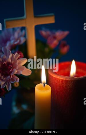 Composition de bougie brûlante, fleurs et croix en bois pour toutes les âmes jour.Convient également aux funérailles, au deuil, au deuil. Banque D'Images