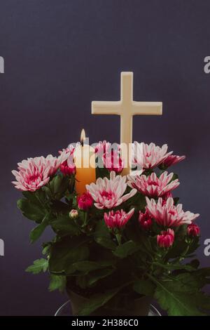 Composition de bougie brûlante, fleurs et croix en bois pour toutes les âmes jour.Convient également aux funérailles, au deuil, au deuil. Banque D'Images