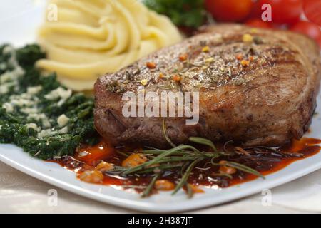 Délicieux steak de bœuf aux épinards et aux pommes de terre décorées avec de l'ail Banque D'Images