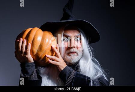 Diable vampire avec Jack-o-lanterne.Halloween homme dans chapeau de sorcière avec citrouille. Banque D'Images