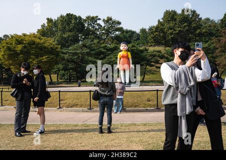 Séoul, Corée du Sud.26 octobre 2021.Les gens prennent des photos de la poupée géante de la série originale Netflix 'Squid Game' au parc olympique de Séoul.La poupée géante de la série originale Netflix 'Squid Game' est exposée au parc olympique de Séoul, en Corée du Sud, du 25 octobre au 23 janvier de l'année prochaine.Crédit : SOPA Images Limited/Alamy Live News Banque D'Images