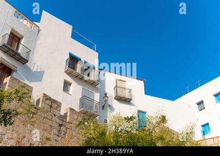 PENI, ESPAGNE - 24 septembre 2021 : Peniscola, Espagne - août 2021.Extérieur des maisons blanchies à la chaux contre ciel bleu clair le jour du soleil. Angle bas. Banque D'Images