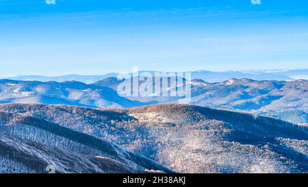 paysage ensoleillé en hiver, haut au-dessus des collines de montagne avec ciel bleu clair, sunbeam au sommet de la colline. paysage montagneux en hiver Banque D'Images