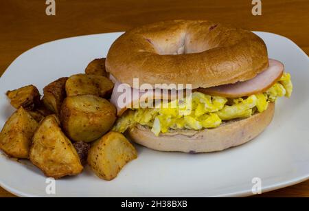 dessus d'œuf sablée avec du bacon canadien sur un bagel aux baies bleues . Banque D'Images