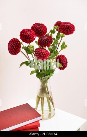 Vase avec dahlias et blocs-notes sur la table contre fond de couleur, gros plan Banque D'Images