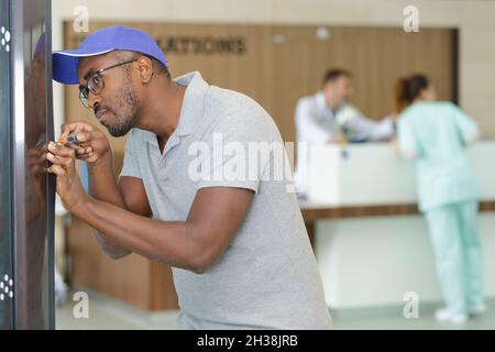 un technicien répare le distributeur de café dans un hôpital Banque D'Images