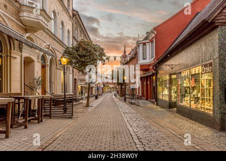 La rue commerçante d'Ystad tôt le matin au lever du soleil avec des vitrines illuminées, Ystad, Suède, 14 septembre 2021 Banque D'Images