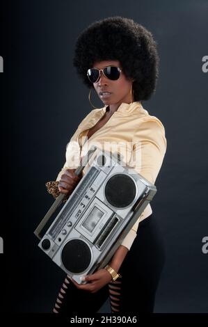 chanteur afro-américain de style rétro assis sur un lecteur de cassettes Banque D'Images