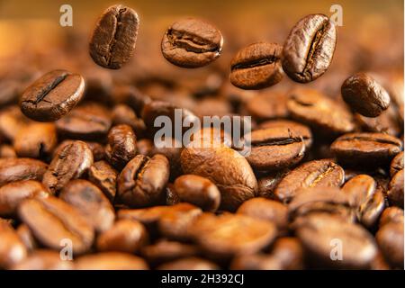 Grains de café Arabica, fruits aromatiques grillés de l'arbre à café.Les grains en mouvement, la macro-photographie. Banque D'Images
