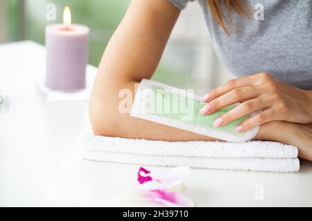 Traitez l'épilation des mains des femmes dans un salon de beauté Banque D'Images