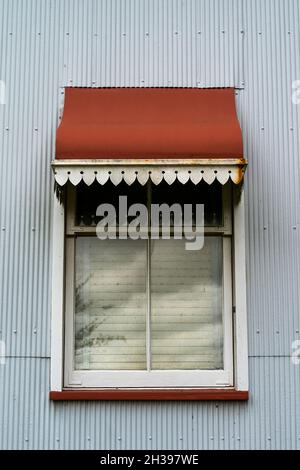 Gros plan sur la fenêtre et l'auvent en fer rouge d'une propriété historique classée au patrimoine Banque D'Images