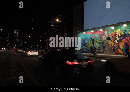 Vue de nuit des feux arrière de voiture qui dépassent une fresque d'artistes de Groundswell et Raul Ayala a le droit d'ouvrir un portail sur le mur mural Bowery de Houston Banque D'Images