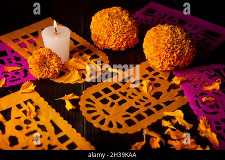 Bougie avec fleurs d'orange Cempasuchil ou Marigold.(Tagetes erecta) et Papel Picado.Décoration traditionnellement utilisée dans les autels pour la célébration de Banque D'Images