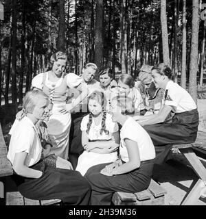 Eine BDM Mädelschaft sitzt dans der Sonne im Freizeitlager am Werbellinsee Altenhof, Brandebourg, 1930er Jahre. Un groupe de filles BDM assis dans le soleil au camp de loisirs du Deutsche Arbeitsfront à Altenhof, Brandebourg, 1930. Banque D'Images