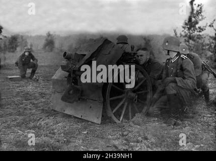 Soldaten des Infanterieregiments 9 auf einem Truppenübungsplatz üben mit dem 7,5 cm leichten Infanteriegeschütz 18, 1930er Jahre Deutschland. Les soldats d'infanterie sur un terrain d'entraînement militaire de l'exercice avec un support d'infanterie fusil, Allemagne 1930. Banque D'Images