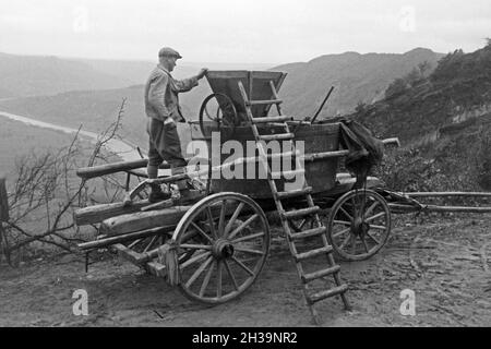 Eine Traubenkelter wird bei der Wein 20 direkt im Weinberg l'im Weinbaugebiet um Serrig an der Saar, Deutschland 1930 er Jahre. Un pressoir mobile dans une vigne à Serrig à Sarre, Allemagne 1930. Banque D'Images