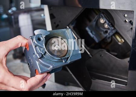 Nettoyage automatique de la machine à café.La femme insère le mécanisme dans la machine à café.Entretien des appareils ménagers Banque D'Images