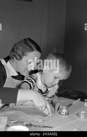 Mutter und genre beim basteln, Deutschland 1930 er Jahre. La mère et l'enfant de faire de l'artisanat, de l'Allemagne des années 1930. Banque D'Images