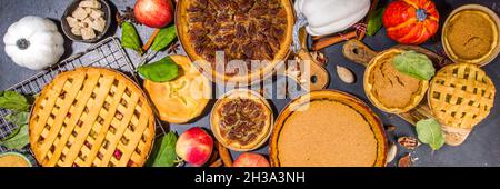 Set variété tartes d'automne.Pacanes, pommes, potiron, petits gâteaux et tartes sur fond de béton avec lumière du soleil vive, ombres sombres vue du dessus Banque D'Images
