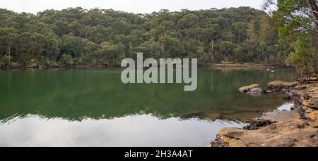 Les gens pagayent un kayak et une planche de promenade dans l'eau immaculée du port supérieur de Sydney, près de Two Creeks Track et du pont de Roseville en Australie Banque D'Images