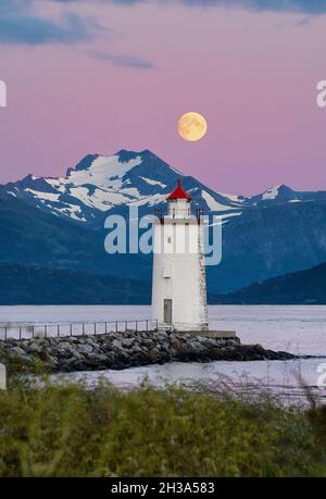 Près de la pleine lune au-dessus du phare de Høgstteinen, Godøy, Norvège Banque D'Images