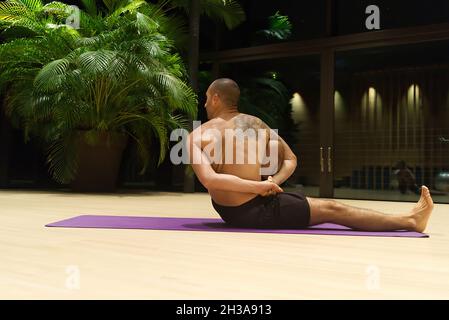 Omar Mura homme caucasien d'âge moyen exécute une position de yoga à l'intérieur. Banque D'Images