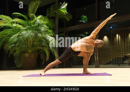 Omar Mura homme caucasien d'âge moyen exécute une position de yoga à l'intérieur. Banque D'Images