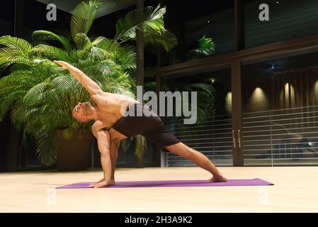 Omar Mura homme caucasien d'âge moyen exécute une position de yoga à l'intérieur. Banque D'Images