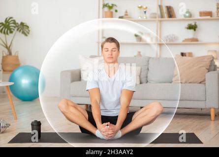 Calme beau millennium européen gars médite avec les yeux fermés dans la salle de séjour à l'intérieur Banque D'Images