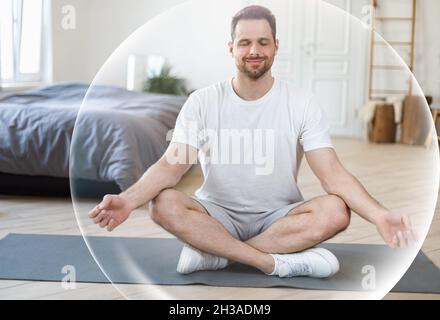 Calme satisfait heureux millénaire homme caucasien méditant avec les yeux fermés dans l'intérieur de la chambre Banque D'Images