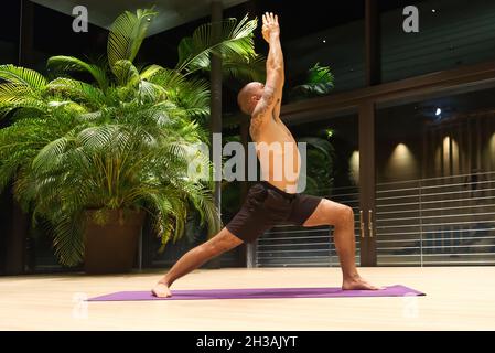 Omar Mura homme caucasien d'âge moyen exécute une position de yoga à l'intérieur. Banque D'Images