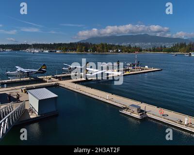 Vue sur le centre de vol du port de Vancouver avec hydravions de la compagnie aérienne canadienne Harbour Air et du parc Stanley en arrière-plan par temps ensoleillé. Banque D'Images