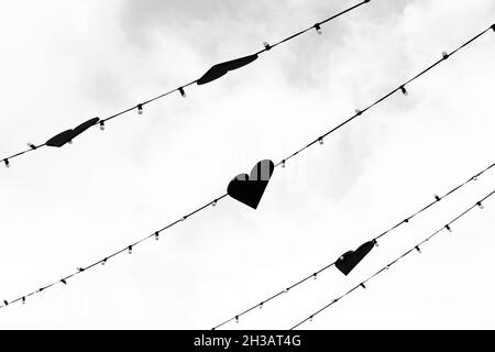 Une guirlande de coeurs étirés dans le ciel, photo en noir et blanc. Banque D'Images