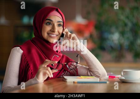 Jeune femme d'affaires du Moyen-Orient ayant une conversation téléphonique Banque D'Images