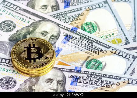 Pièces de monnaie en bitcoin d'or (CTB) sur fond de billets de 100 dollars américains.Concept de monnaie virtuelle et de crypto-monnaie numérique. Banque D'Images