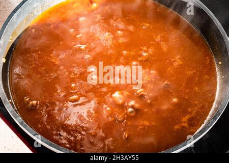 cuisson de goulash avec du bœuf, de la tomate et du paprika dans une poêle à frire profonde dans la cuisine maison Banque D'Images