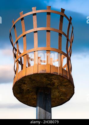 Vieux panier de feu à éclats rouillé sur la plage de Greatstone avec un ciel bleu profond derrière Banque D'Images