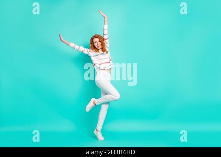 Pleine longueur de corps photo curly femme souriante dansant à la fête surjoyed isolé couleur turquoise arrière-plan Banque D'Images