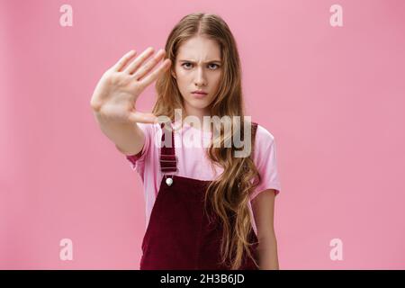 Une femme proteste contre les tests de produits sur des animaux.Jeune fille pleine d'assurance avec de longs cheveux ondulés frognant regarder SCtrict à la caméra tirer Banque D'Images