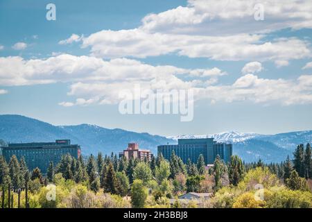 06 01 2021 South Lake Tahoe USA - vue lointaine des casinos imposants près du lac avec des montagnes enneigées au loin et ciel bleu nuageux Banque D'Images