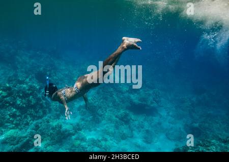 La femelle nage sous l'eau dans les eaux bleu hawaïennes Banque D'Images