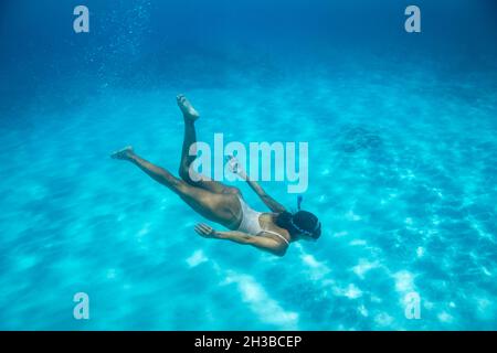 La femelle nage sous l'eau dans les eaux bleu hawaïennes Banque D'Images