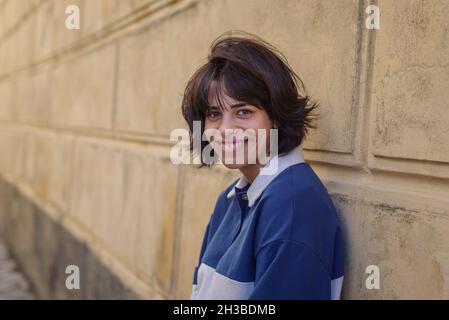 Portrait of teenage Girl standing by wall Banque D'Images