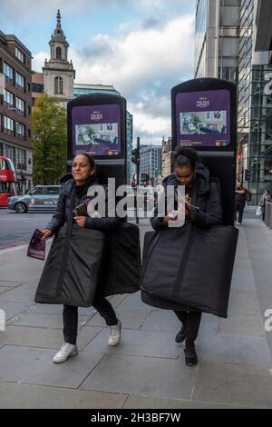 Londres, Royaume-Uni.27 octobre 2021.Les travailleurs descendent Bishopsgate dans la ville de Londres et portent des panneaux sandwich modernes faisant la promotion de la propriété à vendre ou à louer dans le quartier de Whitechapel.Credit: Stephen Chung / Alamy Live News Banque D'Images