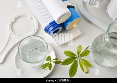 Verre d'eau purifiée avec équipement domestique et filtres sur table et cuisine en arrière-plan avec équipement osmotizer.Vue de dessus.Comp. Horizontale Banque D'Images