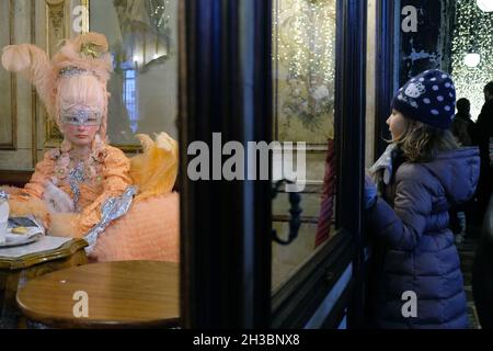 Une petite fille regarde un masque à l'intérieur du café Florian.Italie 26 février 2017,(MVS) Banque D'Images